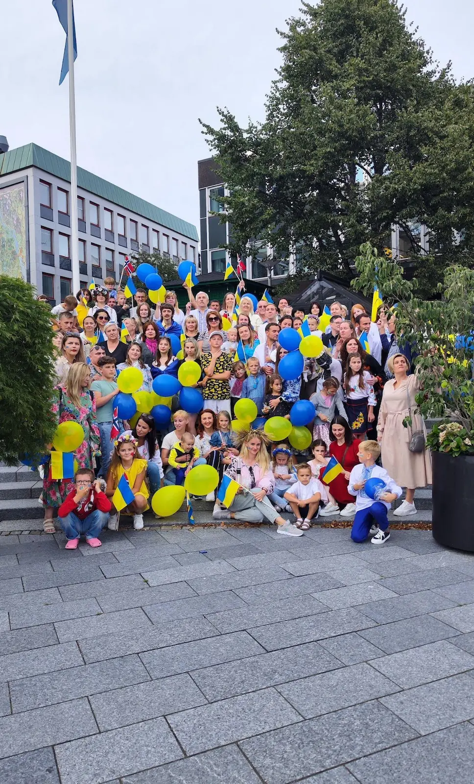Stor gruppe barn og voksne samlet med blå og gule ballonger på torget under feiringen av Ukrainas uavhengighetsdag i Larvik.