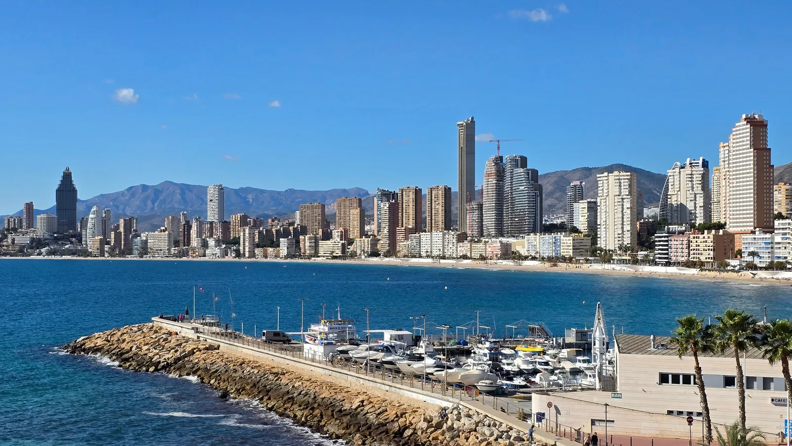 Benidorms skyline og småbåthavn sett fra kysten på Costa Blanca en klar dag