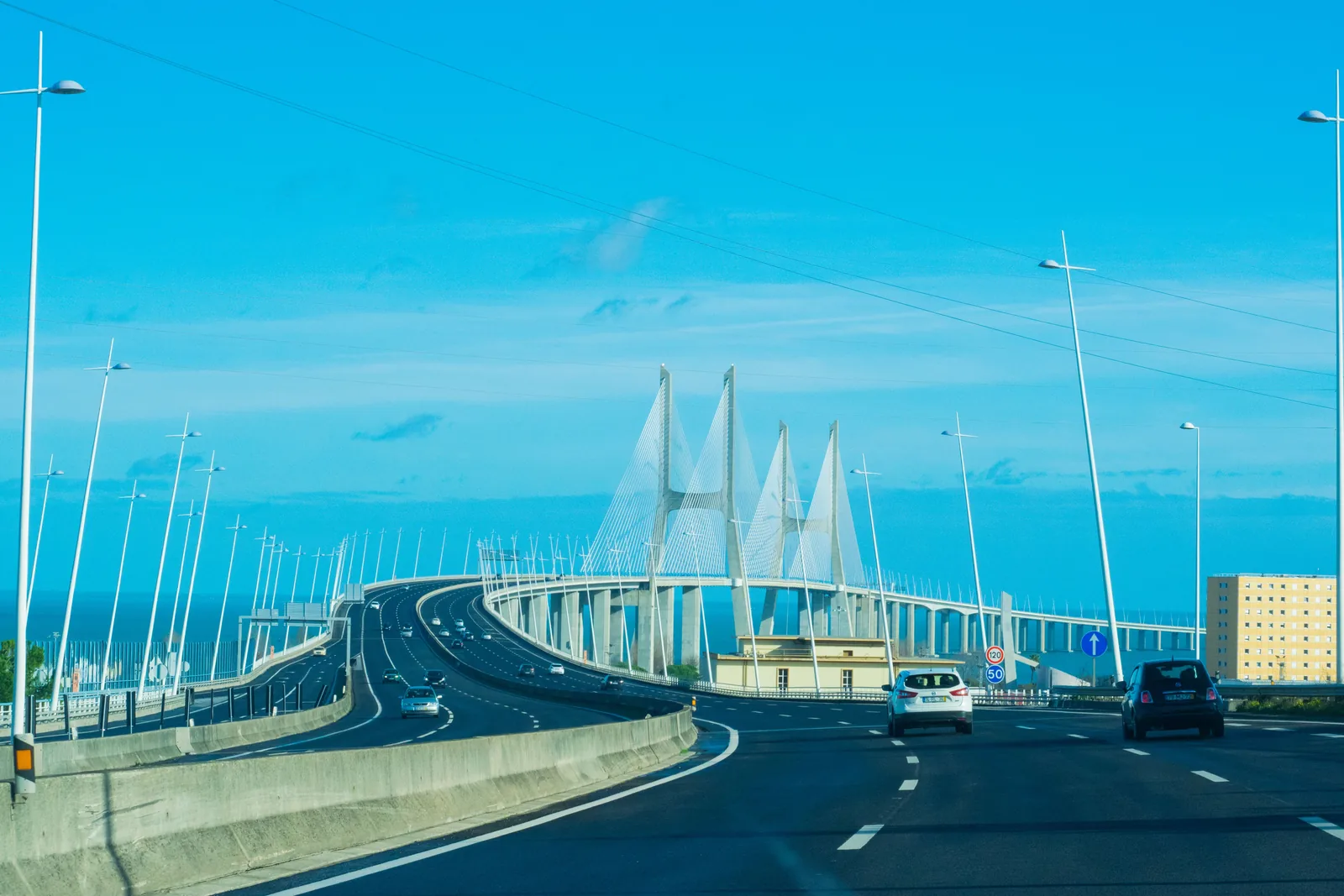 Biler på motorveien mot Vasco da Gama-broen over Tejo ved Lisboa en solrik dag