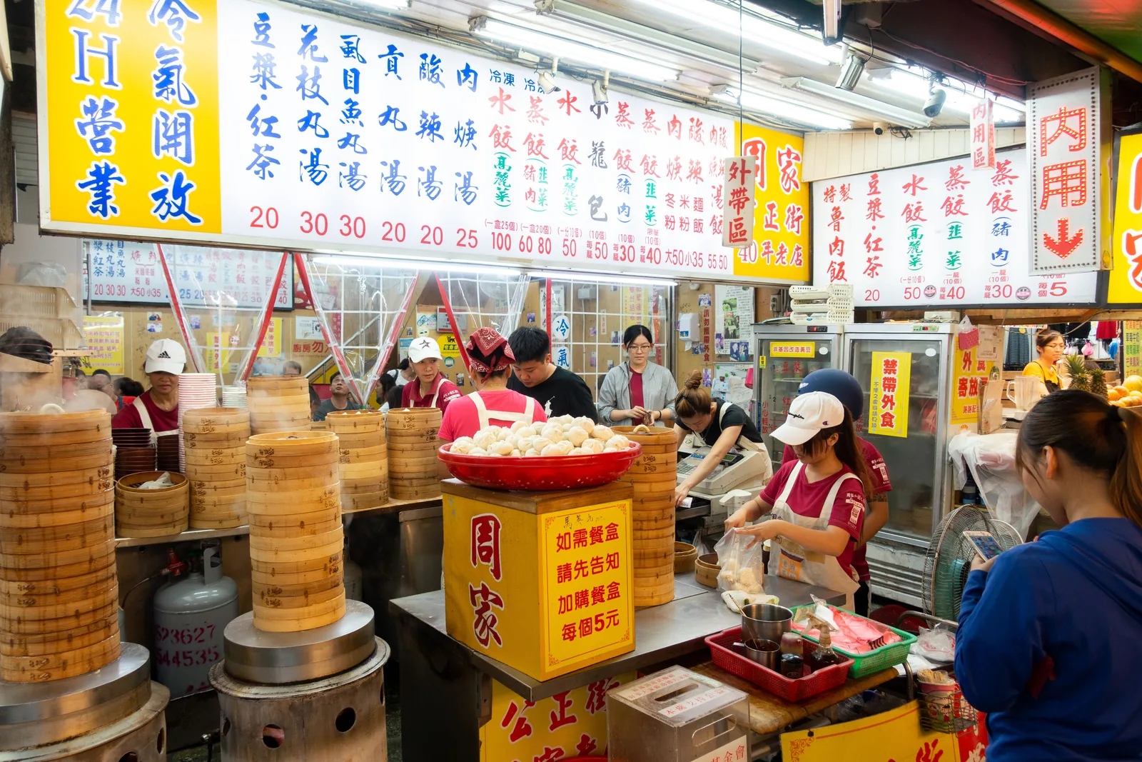 Madstand med dampkurve og dumplings på et natmarked i Taiwan, hvor kokkene tilbereder maden foran kunderne