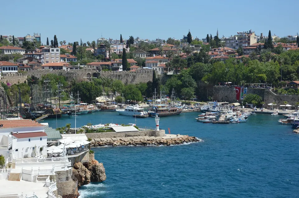 Den gamle havnen i Antalya med båter, bymur og hvite hus i skråningen
