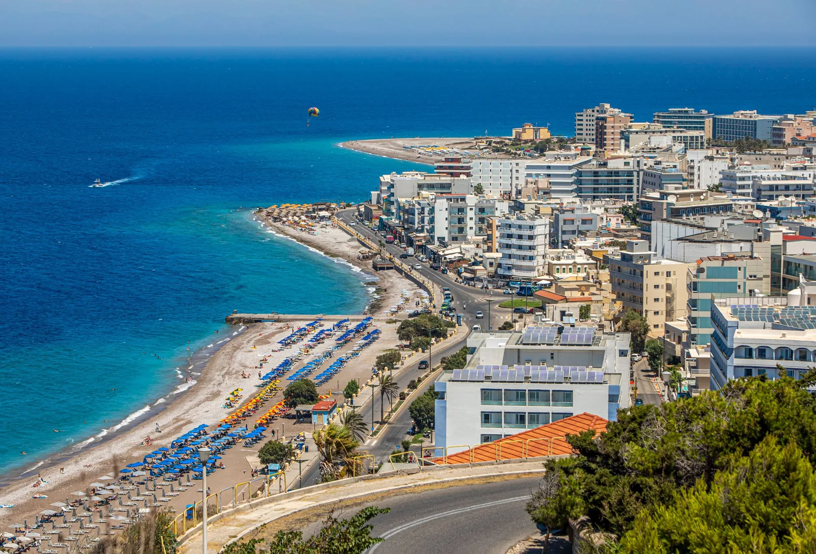 Rhodos by sett ovenfra, med strandpromenade, solsenger og blått hav